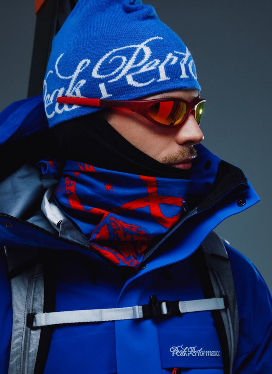Model w czapce Peak Performance 40Y, goglach i niebieskiej kurtce narciarskiej GORE-TEX